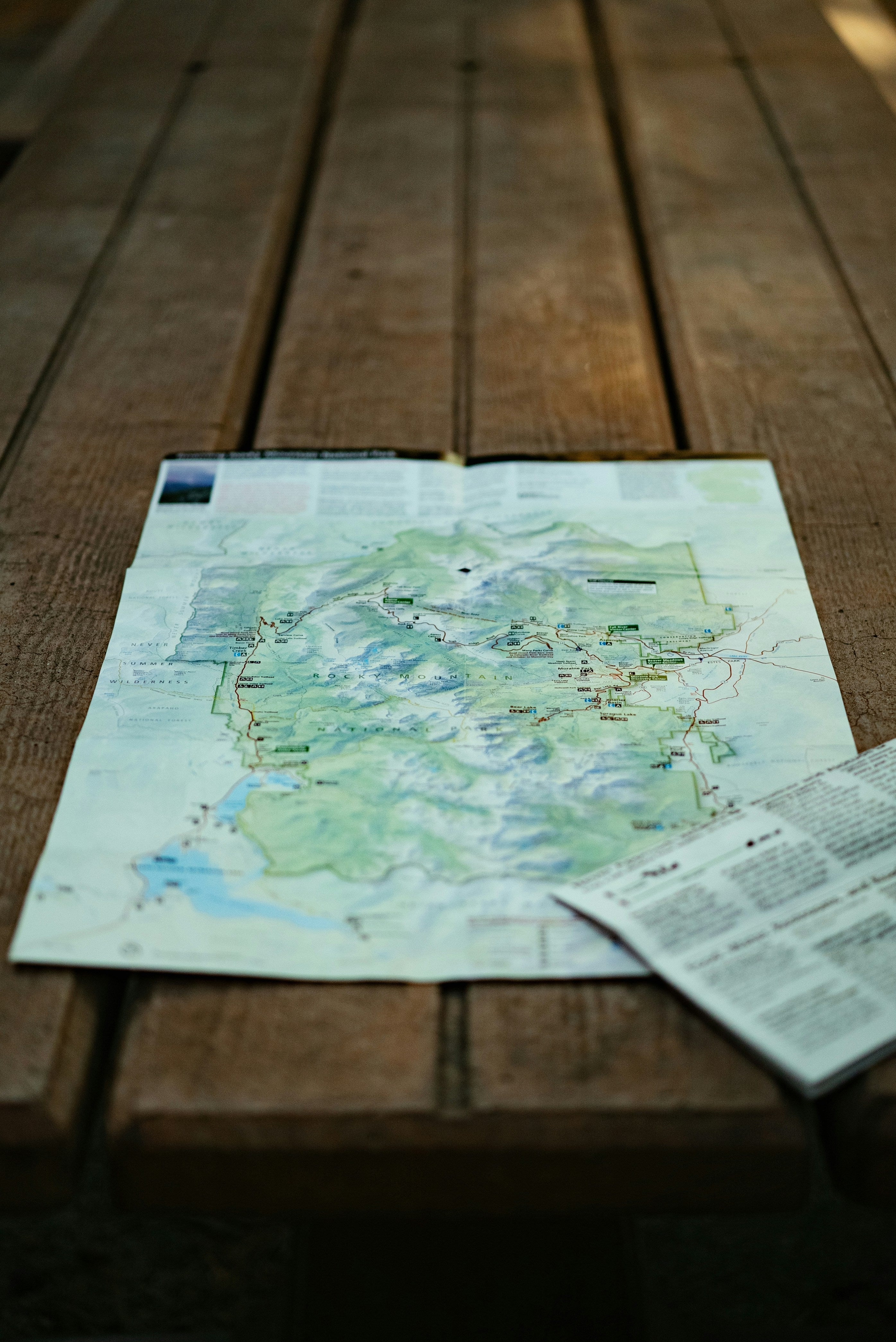 En utvikbar karta över ett bergsområde som ligger på ett rustikt träbord utomhus.