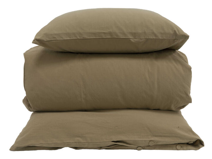 En studiobild mot vit bakgrund som visar en stapel med sängkläder i en enfärgad, dovt olivgrön eller brunbeige nyans. Stapeln består av ett vikt täcke i mitten med ett matchande örngott ovanpå och ett under. Det understa örngottet visar detaljer som små knappar längs öppningen.